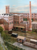 The large factory with the tall chimney covers the curved tracks which lead to the hidden holding tracks.
